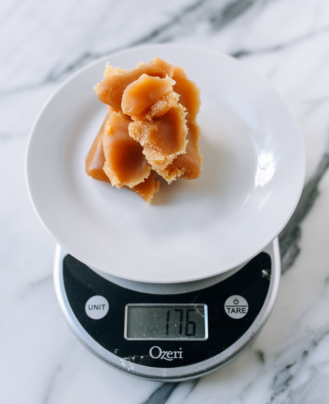 Measuring lotus paste on digital kitchen scale