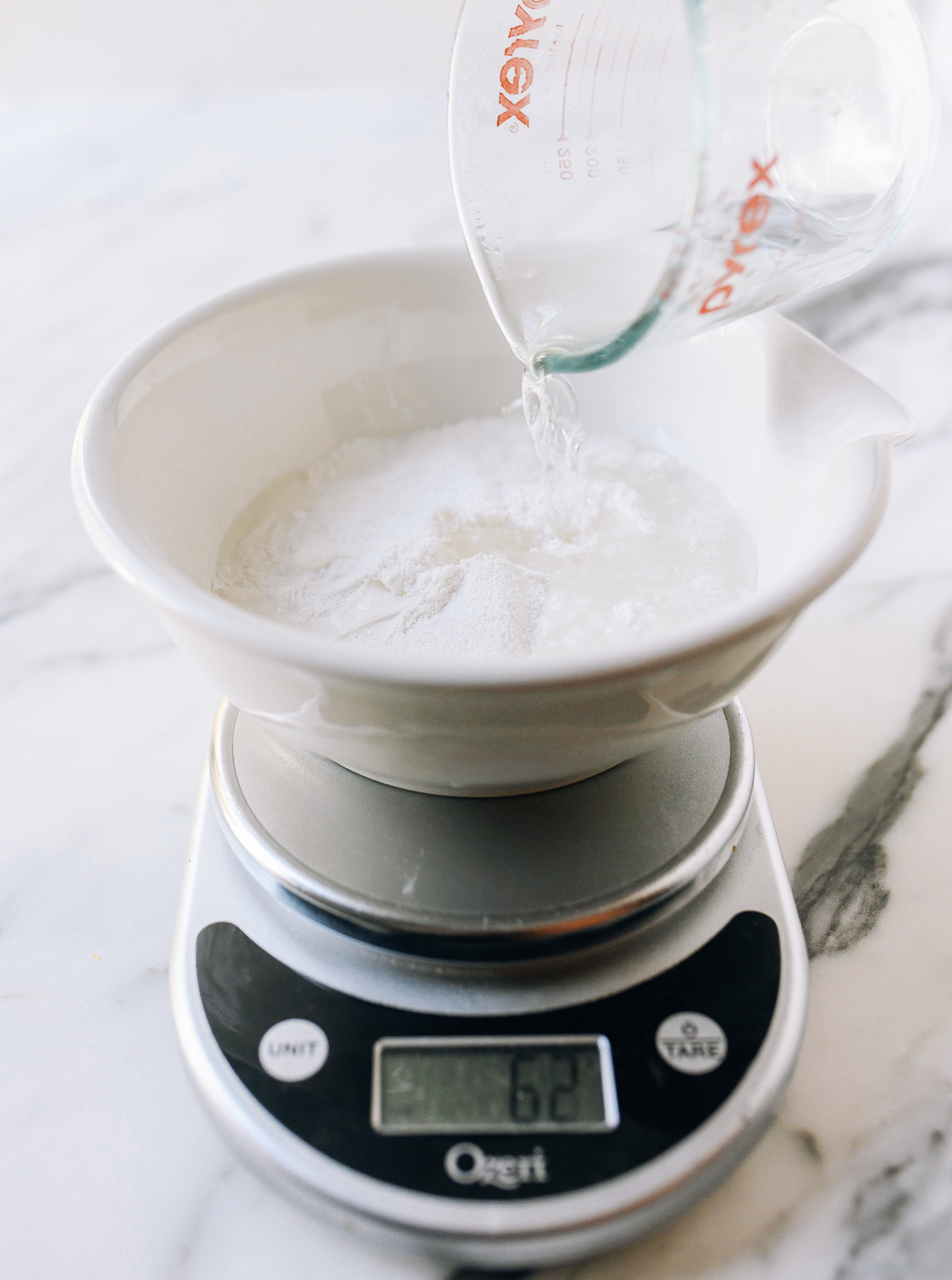 Pouring boiling water into mixing bowl with glutinous rice flour and sugar.