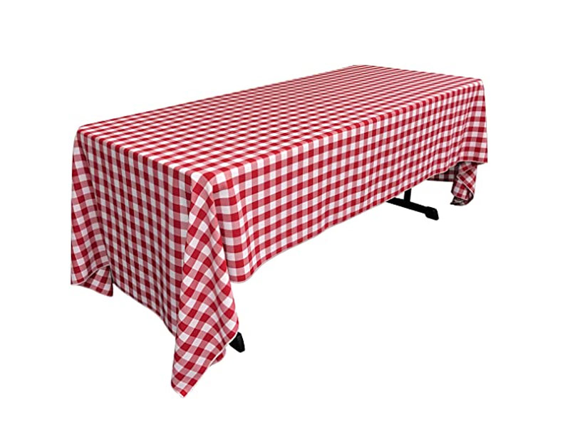 Picnic red and white checkered linen on long table with white background.