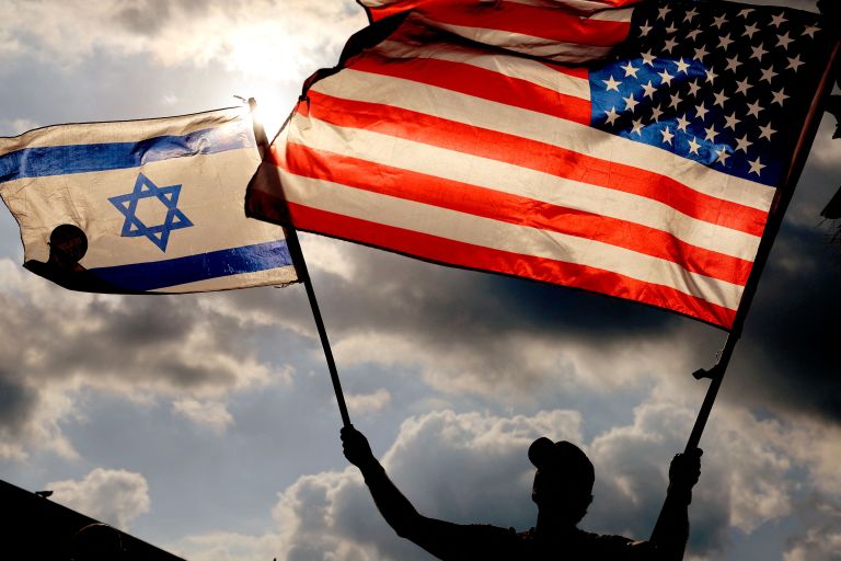 A protester waves US and Israeli national flags during a demonstration in front of the US embassy in Tel Aviv on September 20, 2023.