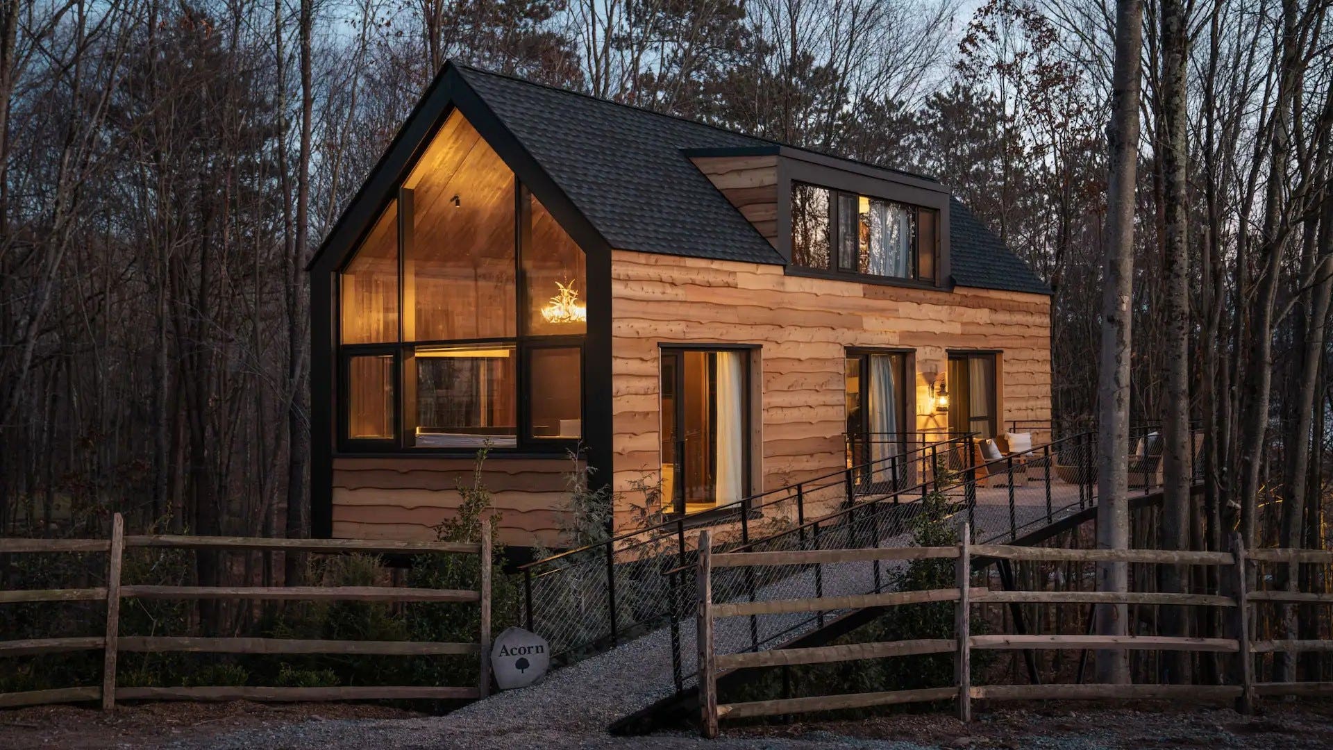 Modern log cabin in the woods at sundown.