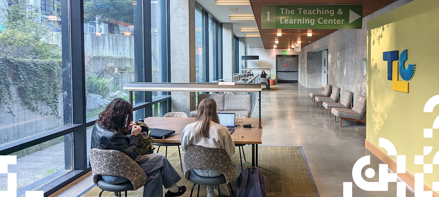 Two people sitting outside the entrance to the new TLC offices in McHenry Library. 