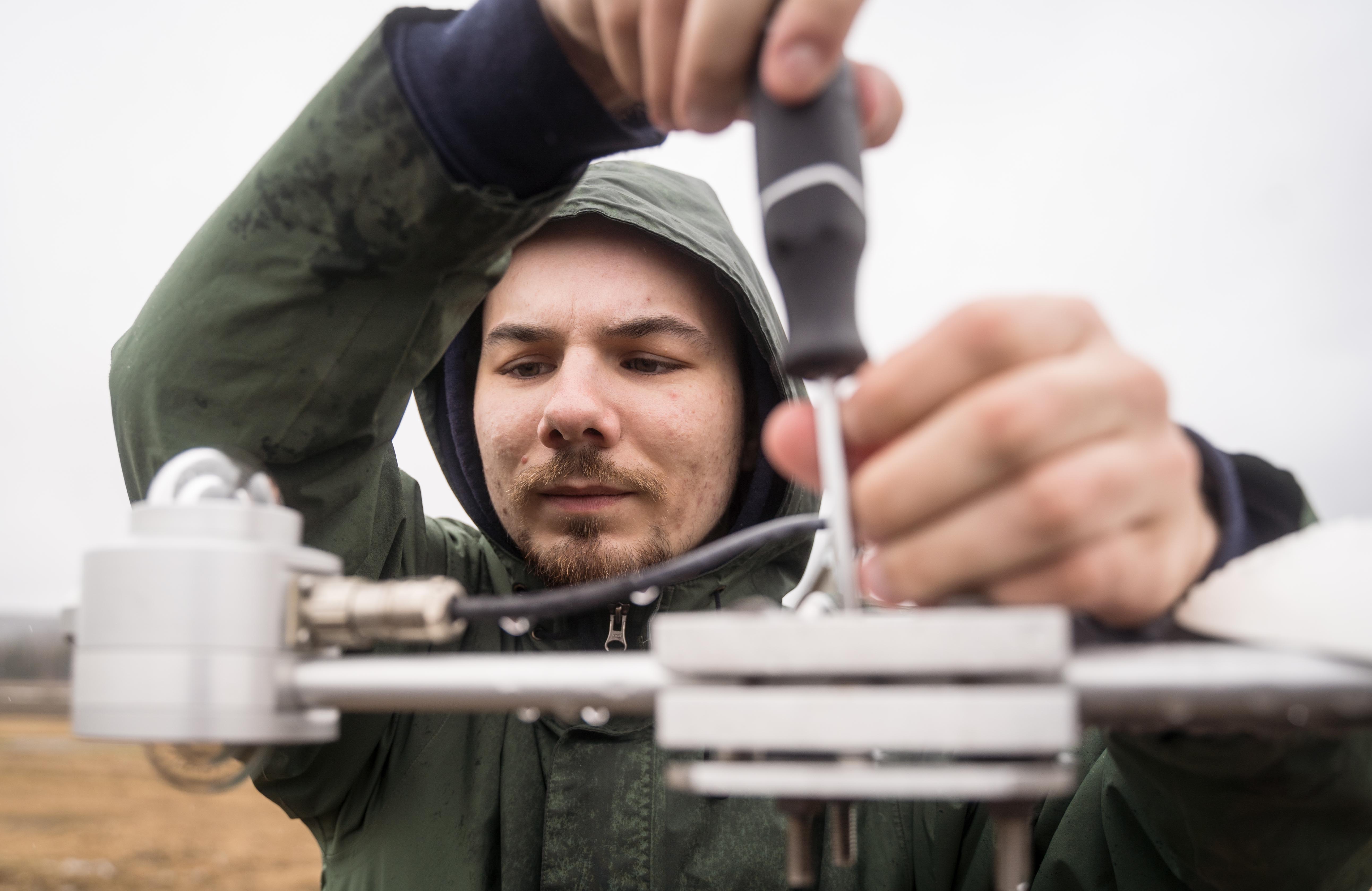 A man works on a weather instrument