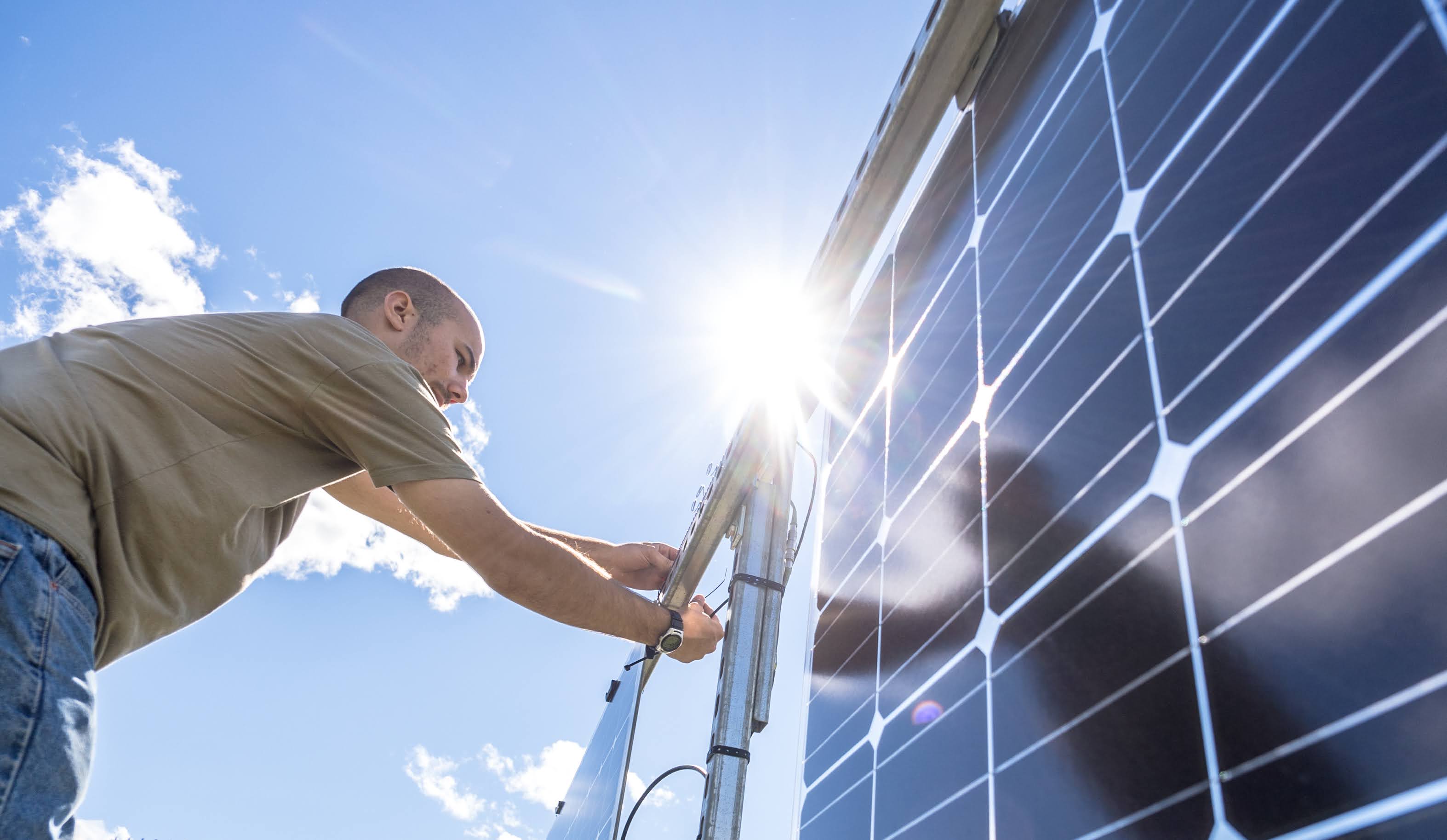 A man works on a solar panel