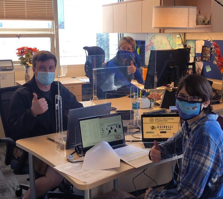 three masked people at a table