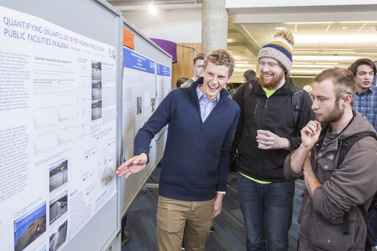 A student discussed a research poster with spectators