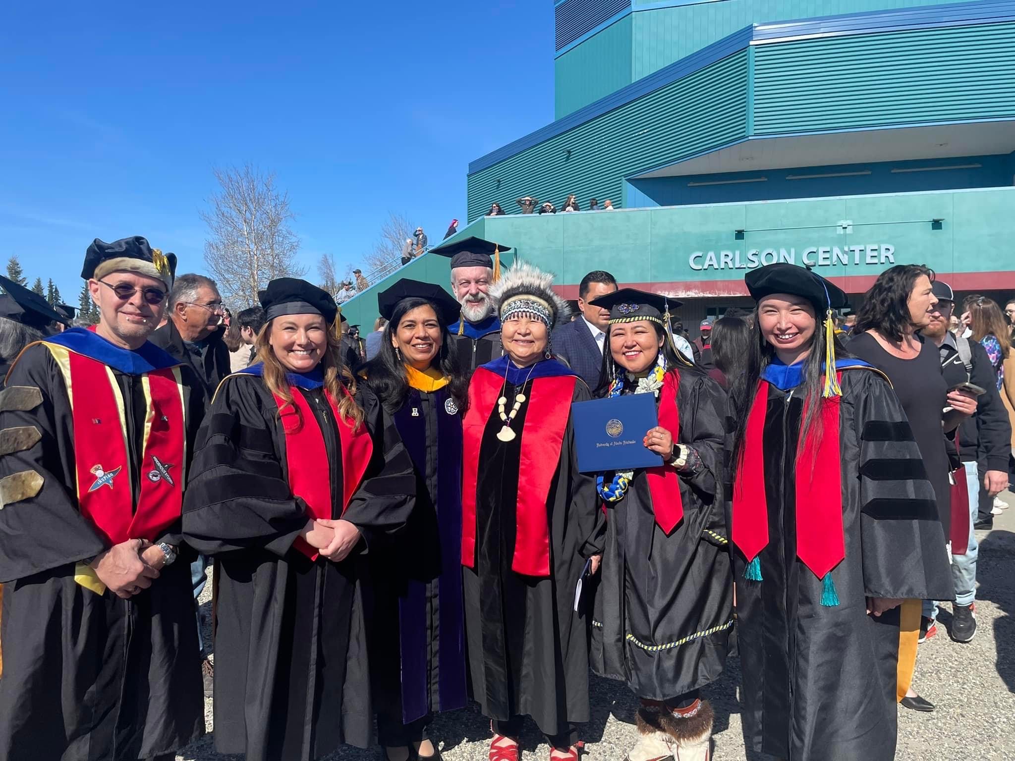 UAF graduates celebrate with members of university faculty and leadership during the 2019 commencement in Fairbanks, Alaska.