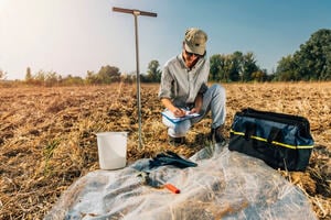 Soil test. Female agronomist taking notes in the field. Environmental protection, organic soil certification, research