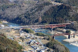 下流側の苗木城址の天守展望台から望む木曽川に架かる岐阜県道6号中津川田立線の玉蔵大橋とその手前に旧北恵那鉄道北恵那鉄道線の木曽川橋梁（2017年3月4日撮影）