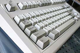 IBM Model M Space Saver (ohne Ziffernblock) von der Seite, zu sehen die deutlich gebogene, ergonomisch geformte Tastaturfläche aller Model M.