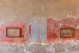 mur à enduit rouge et bleu, avec deux tableaux