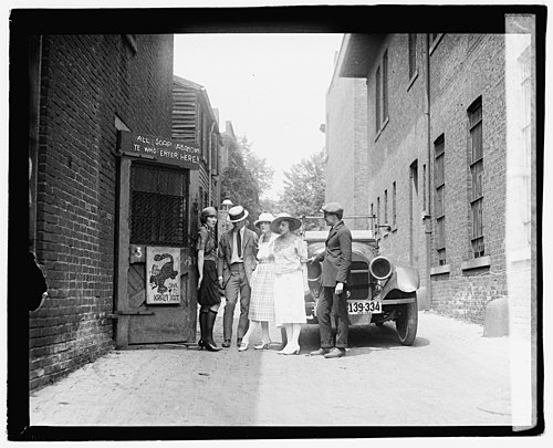 Several patrons and a flapper await the opening of the Krazy Kat Klub in 1921, a speakeasy located in Washington, D.C.