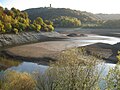 Urftstausee bei Niedrigwasser mit der ehemaligen NS-Ordensburg Vogelsang im Hintergrund