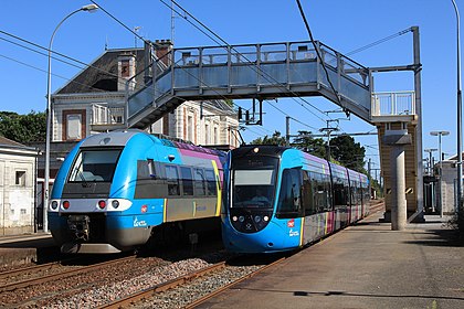 Een tram naast een trein