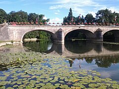 Photographie en couleurs d'un pont de pierre avec ses arches.