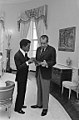 Sammy Davis Jr., (1925-1990), dans le bureau ovale avec Richard Nixon, le 4 mars 1973.]].