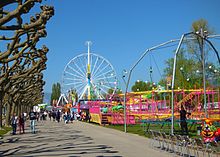 Vue sur une étendue publique avec des attractions foraines.