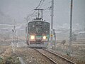 雪の中を走る125系電車（谷川駅 - 久下村駅間）