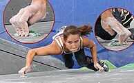 A climber using the crimping and edging technique on an indoor climbing wall