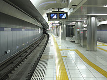 Photo of a train station platform with yellow pavings on the edge of the platform