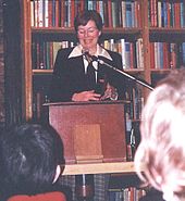 Bannon in a bookstore at a podium reading in front of an audience