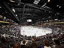 A hockey rink with seats sparsely filled