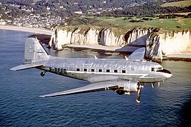 Un DC-3 aux couleurs d'Aigle Azur en Normandie, la falaise d'Aval en arrière-plan.