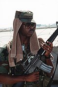 An airman armed with an M-16 rifle stands guard at an airfield during Operation Desert Shield DF-ST-91-07079.jpg