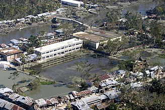 large areas of still water behind riverside buildings