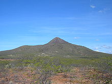 An extinct volcano wi spairse greenery in the foregrund