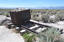 Photographie du Mono Lake, où l'on voit un chariot de mineur, seul, dans cet immense désert ; il représente le film L'Homme des Hautes Plaines, puisque le tournage de ce film s'est effectué là-bas