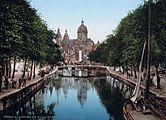 Aan de noordzijde van de Oudezijds Voorburgwal wordt het uitzicht beheerst door de Sint-Nicolaasbasiliek. Foto van circa 1890.