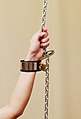 Model Ina bound with leather bondage cuffs to chains