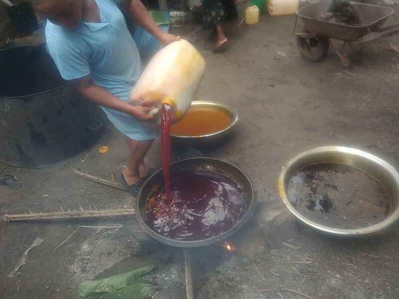 File:Pouring and Simmering freshly extracted palm oil in a pot over a flame.jpg