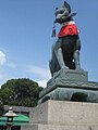 Un renard en face d'un Inari-jinja avec une clef dans la gueule.