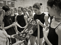 Delles integrantes del conxuntu español y los entrenadores Rosa Menor y Noelia Fernández reparando un maillot.