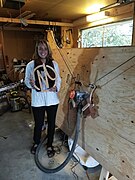 Hannah in front of Maslow CNC holding Maslow logo