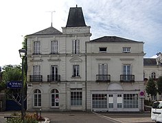 Photographie en couleurs d'un bâtiment surmonté d'une tour couverte en ardoises.