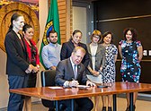 Photo of a man signing a document