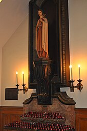 An image of a religious statue of a woman surrounded by candles