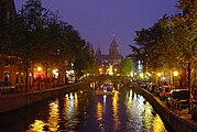 Oudezijds Voorburgwal en silhouet van de Sint-Nicolaasbasiliek bij nacht