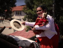 Chola cuencana con una reproducción de la imagen del Niño Viajero durante el Pase del Niño Viajero 2013 en Cuenca, Ecuador.