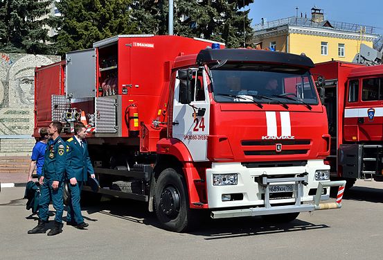 Russian firefighters in the uniform of the EMERCOM see an ANRM-130-1/150 Potok pump and water hose containerized firefighting vehicle based on a KamAZ-6520.