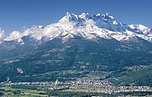 Vue générale de l'agglomération et de montagnes enneigées la surplombant.