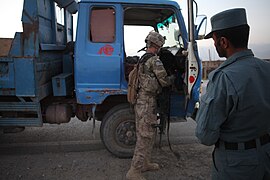 A military working dog completes a vehicle check before an Afghan police officer conducts a follow up inspection.jpg