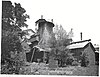 Stack, wheel house, and casting house of Isabella Furnace about a decade after abandonment. The wheel house is dilapidated and collapsing; the rest of the structures are slightly overgrown but otherwise in good repair.