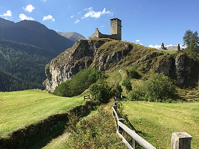 Ruine auf Felsen oberhalb des Inntals mit Wanderpfad.