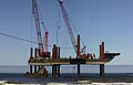 Jackup barges being used to dismantle a ship that was wrecked at sea.