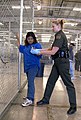 A CBP Border Patrol agent conducts a pat down of a female Mexican being placed in a holding facility
