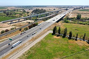 The same viaduct completed in April 2021. Adjacent are the SR 99 freeway and, between them, a single-track railroad line which is used for freight.